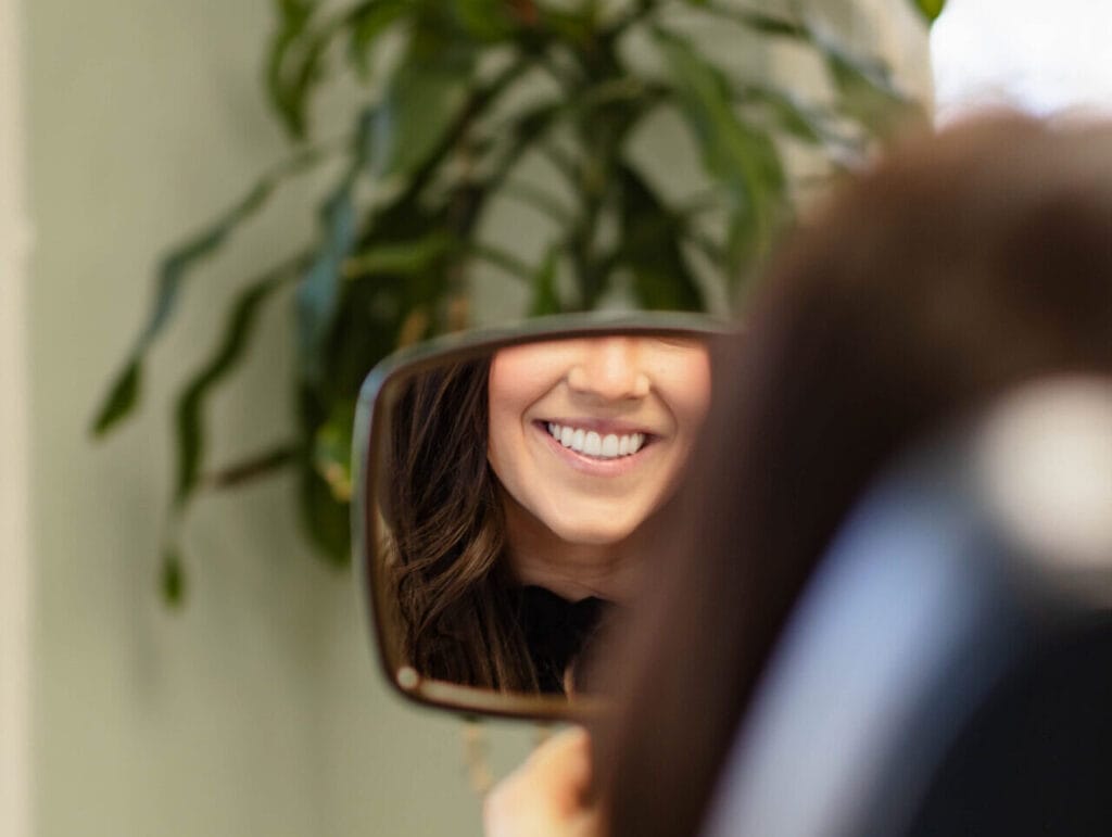 Female patient admiring her smile after orthodontic treatment